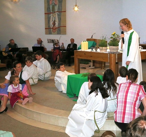 Seelsorgerin Eva mit Kindern beim Gottesdienst in der Kirche